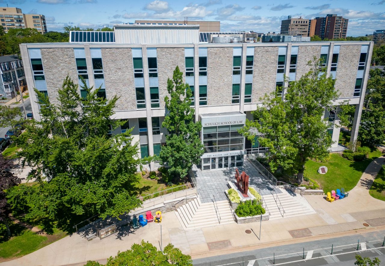 An aerial view of the entrance to the Weldon Law building in fine weather with greenery surrounding and colourful chairs out front.