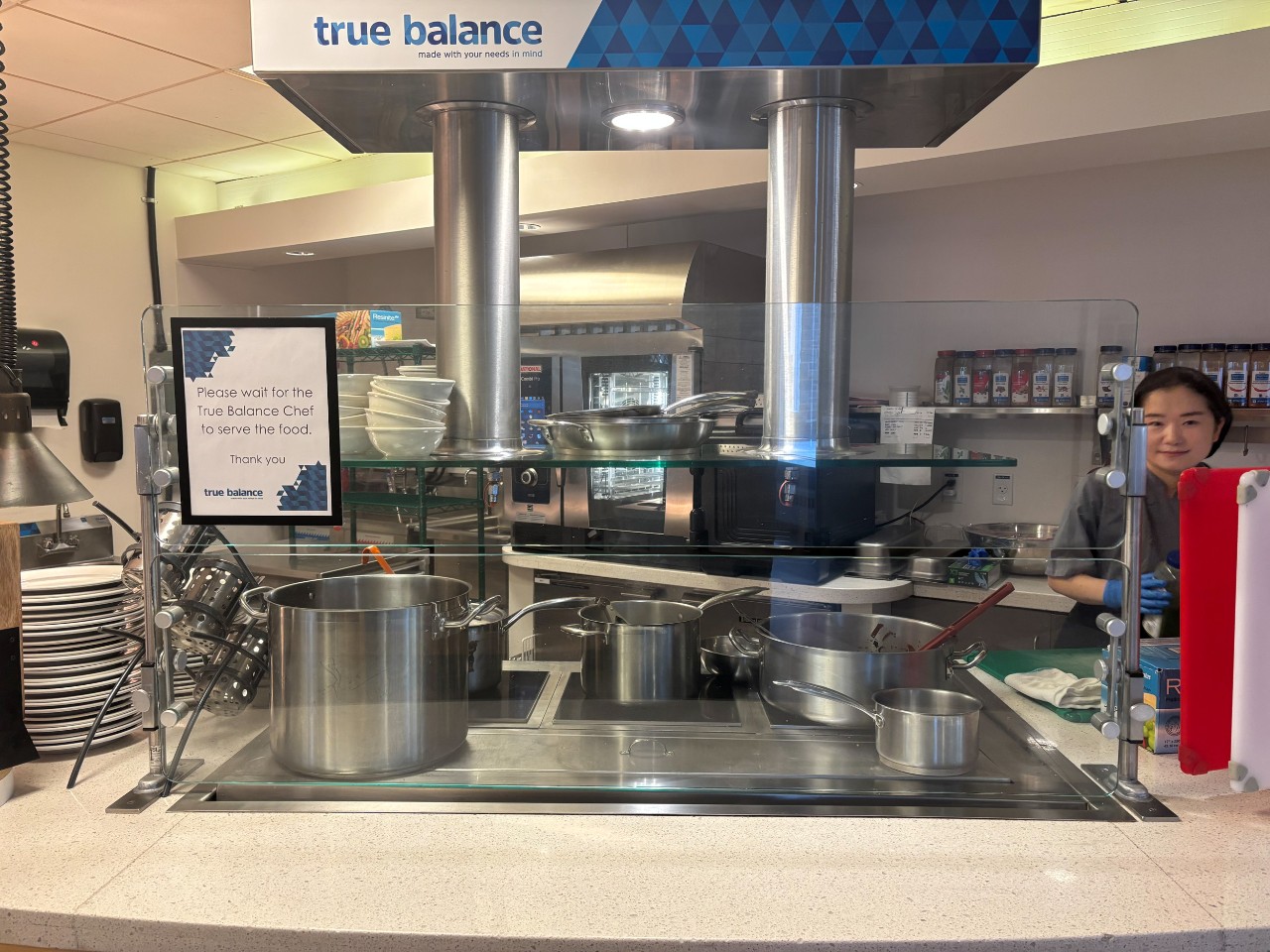 A staff member works behind the counter at the True Balance station preparing dishes in a dedicated kitchen