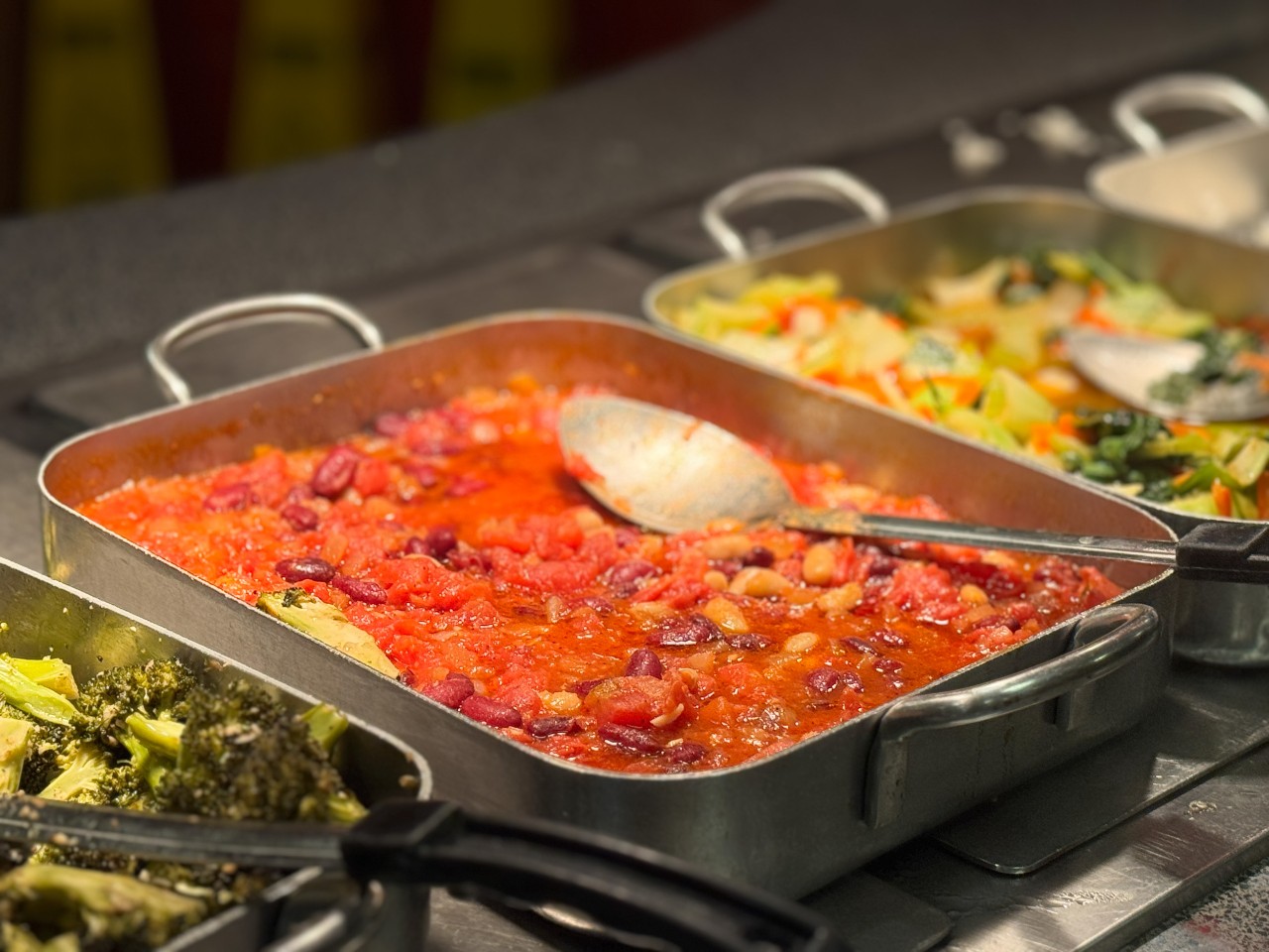 A colourful array of cooked vegetables in trays on the serving counter