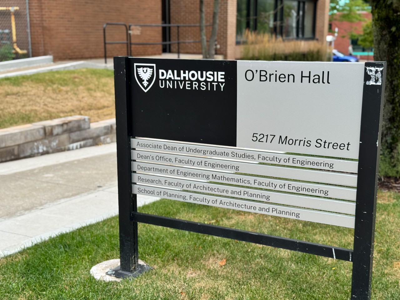 The O'Brien Hall sign stands in a grassy area beside the building along Morris Street