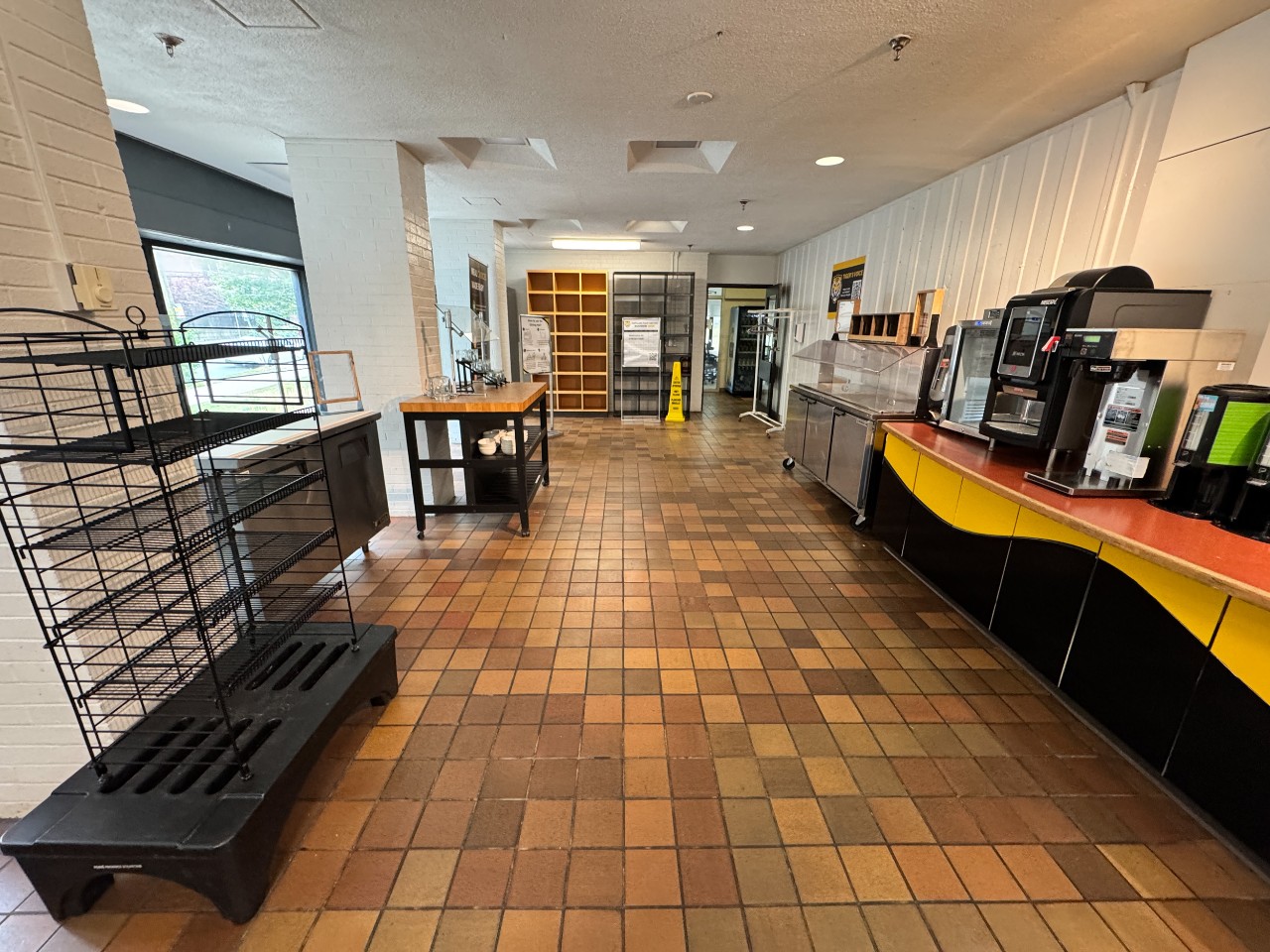 Looking toward the entrance, you can see the shelves used for back check, and counters and racks for food items, with the coffee bar on the right