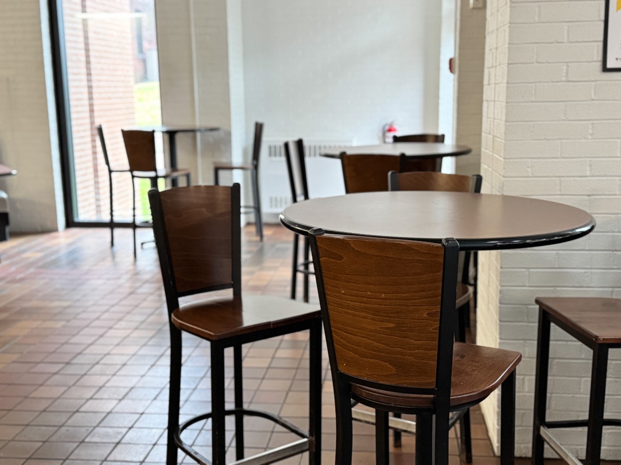 Bar-height round tables are near the large windows