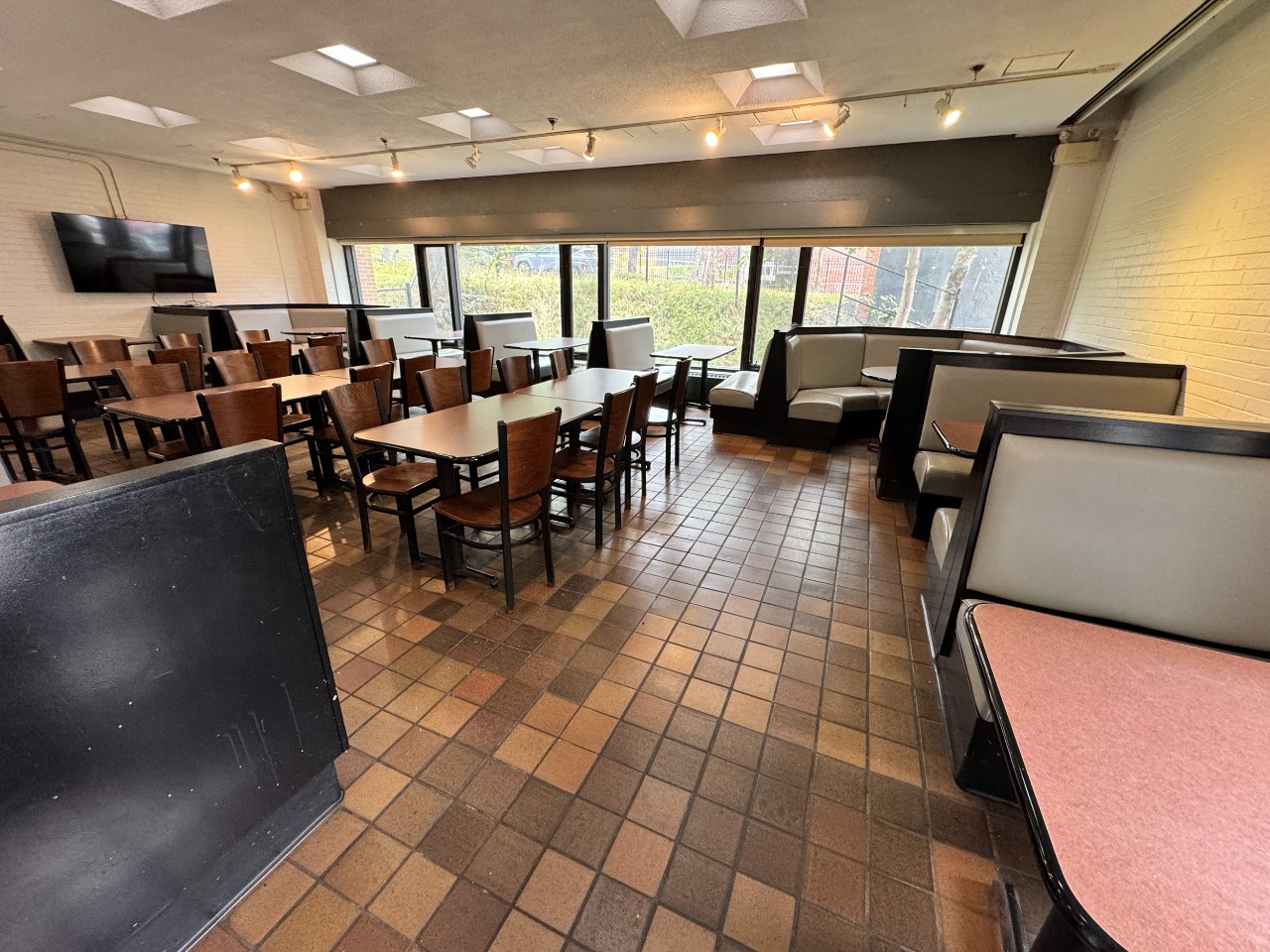 The seating area has a combination of long tables and upholstered booths