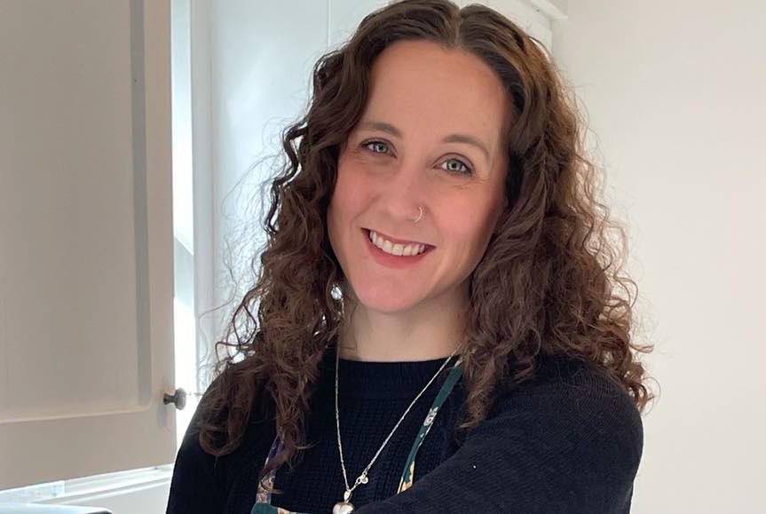 A photo of Liz Muggah, a woman with curly brown hair, in a kitchen