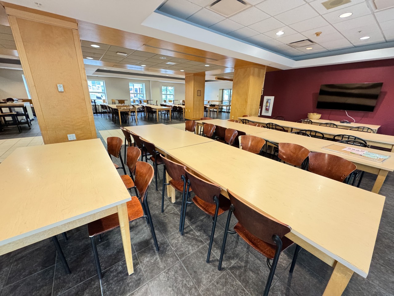 The seating area has long tables with plenty of chairs, as well as a large TV on the wall