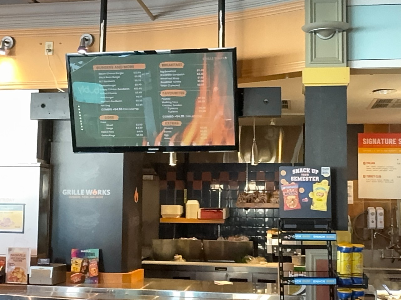 The Grille Works counter in the LSC has a large menu board above the counter and a food prep area behind