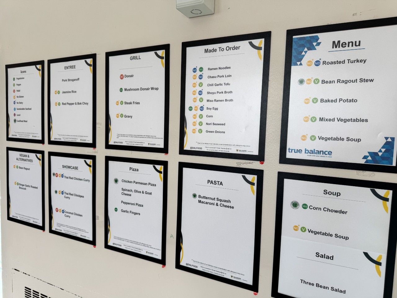 Menus posted on a wall near Howe Hall show labelling icons next to the menu items