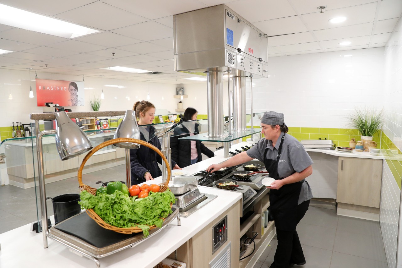 Cook serving food to student in the Jenkins Hall servery