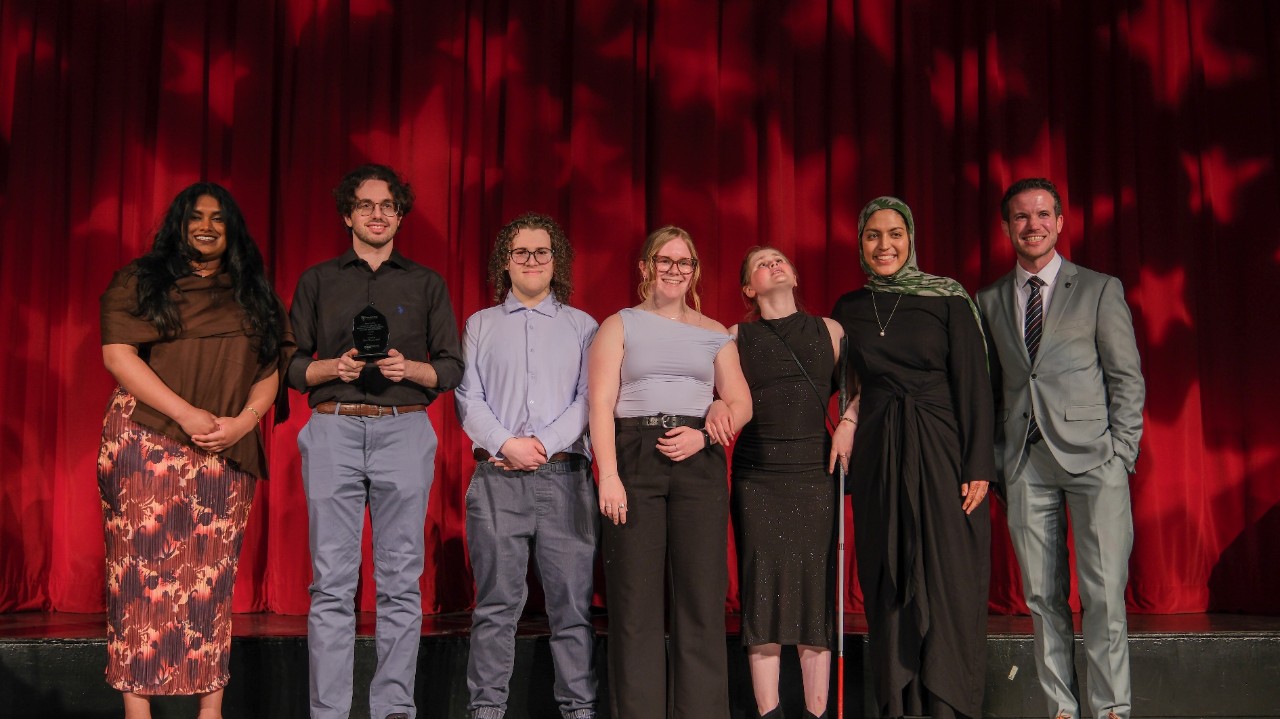 Students accepting the President's EDIA award on stage.