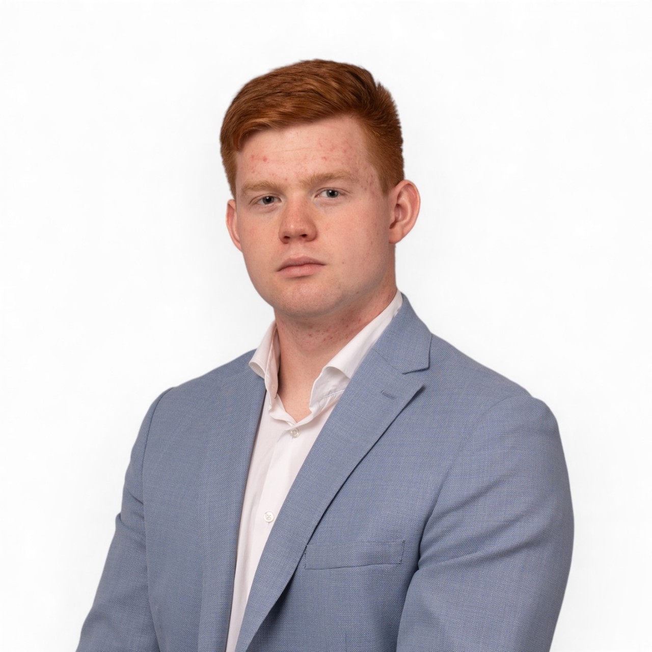A portrait of Isaac wearing a white shirt and light blue blazer.