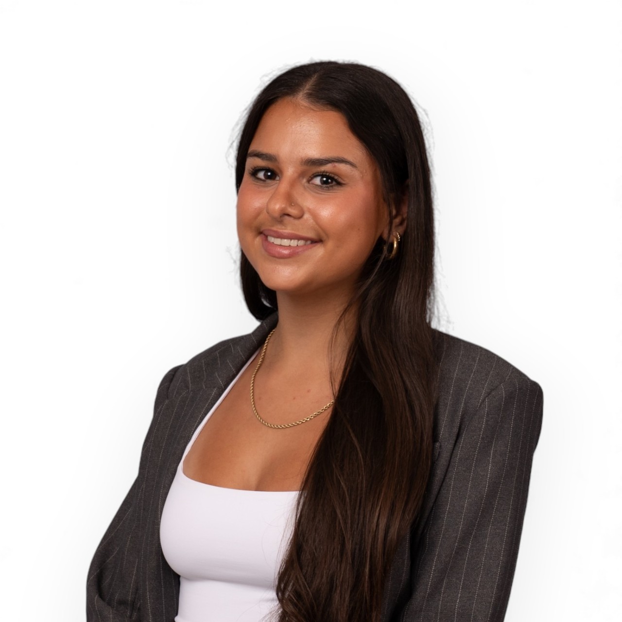 A portrait of Gaby wearing a white shirt and grey pin-striped jacket.