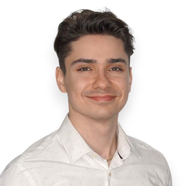 A portrait of Cyril Jurdak O'Brien wearing a white buttoned shirt.