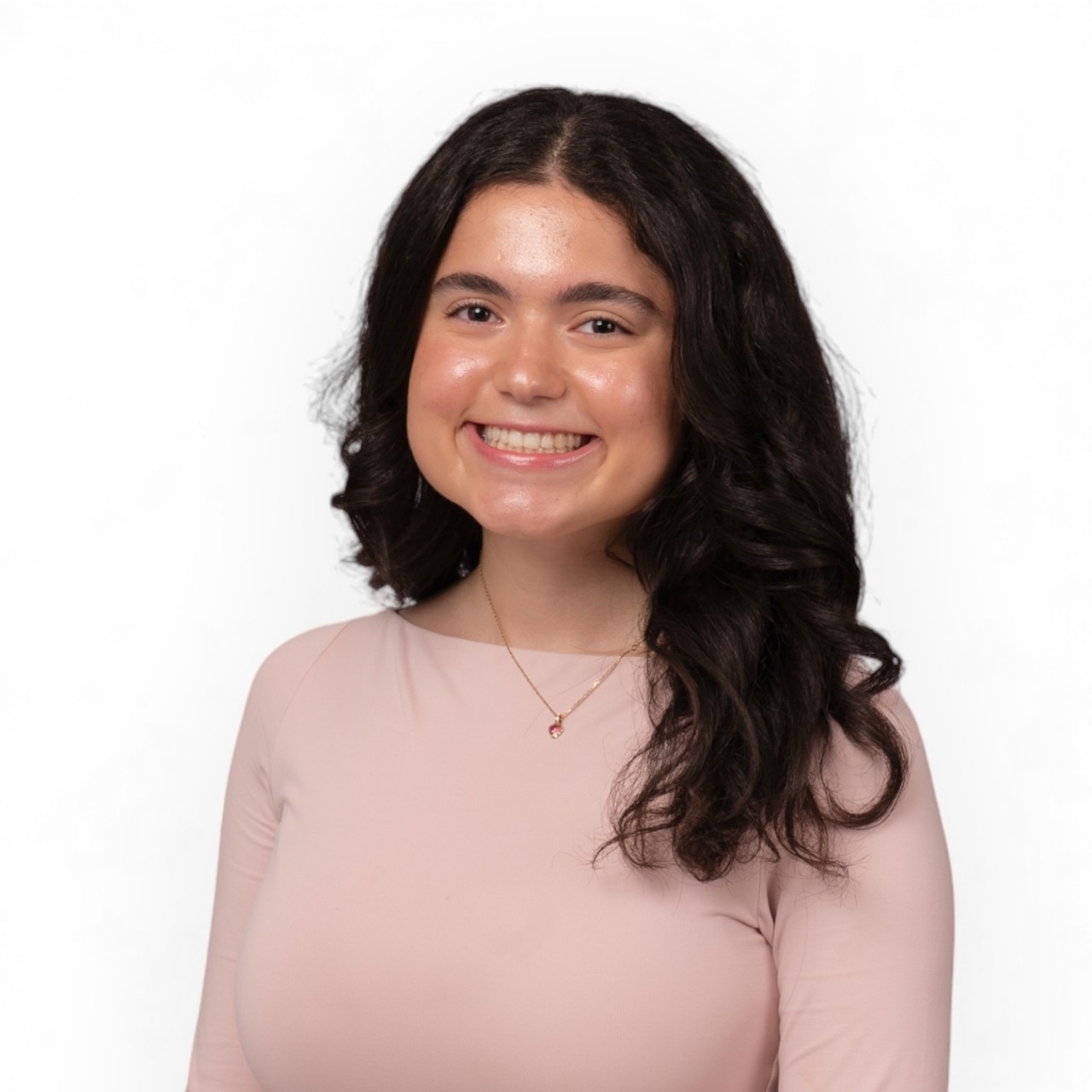 A portrait of Wateen smiling, dressed in a pink top and necklace.