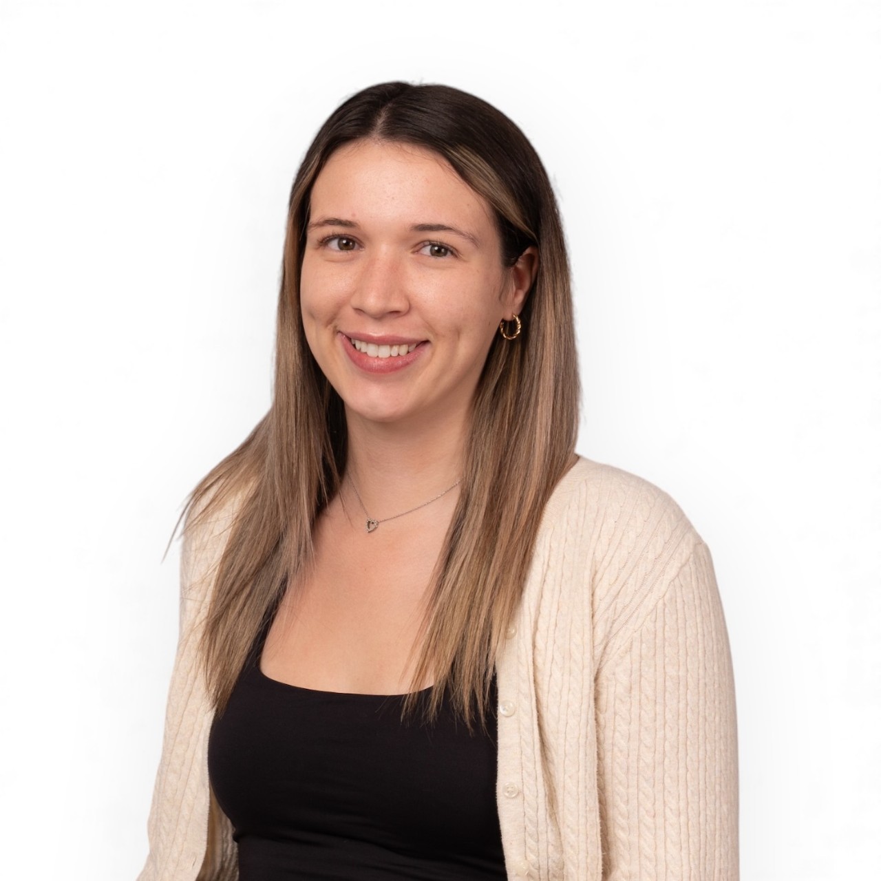 A portrait of Brooklyn wearing a black top and cream-coloured cardigan.