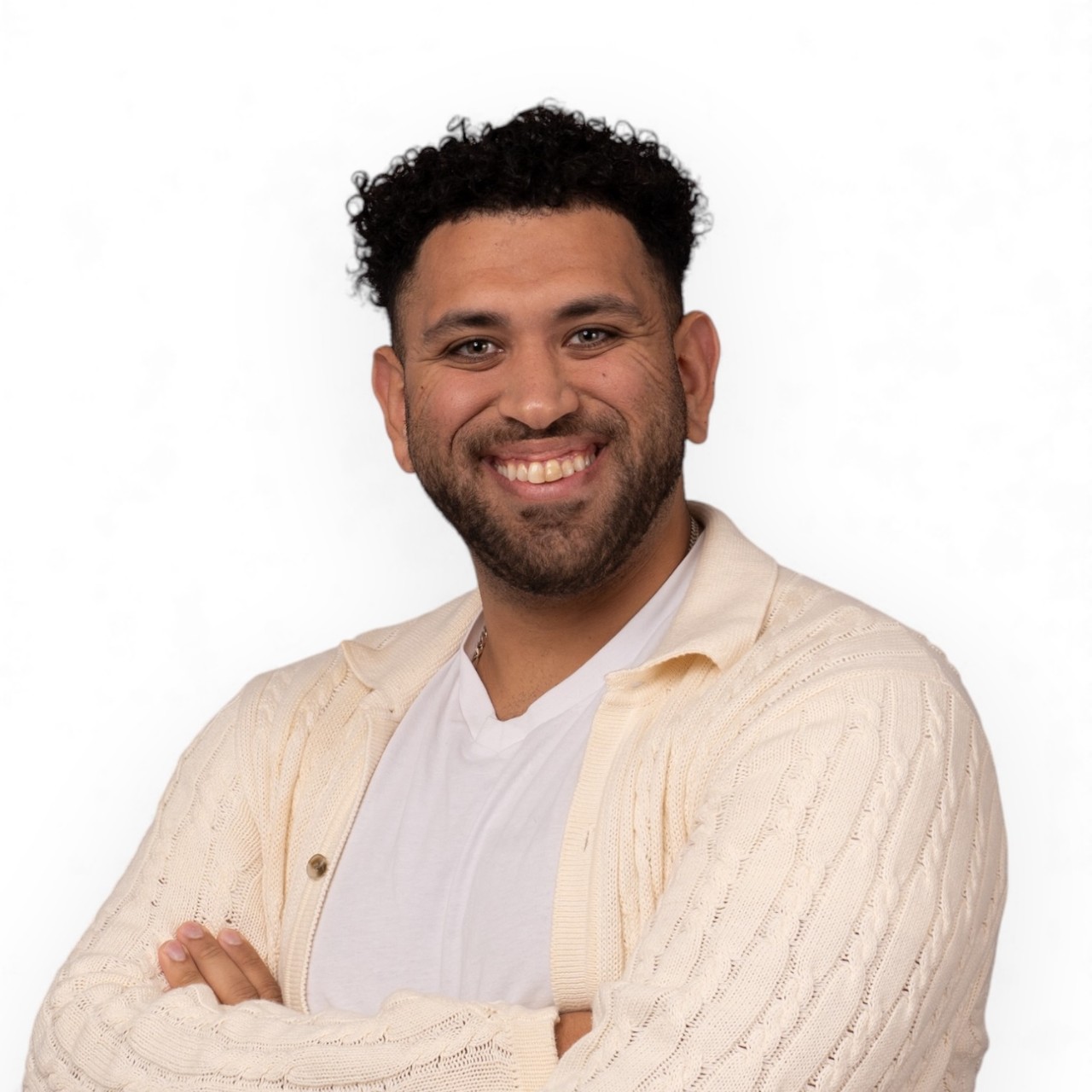 A portrait of Jeremiah wearing a white shirt and cream-coloured cardigan.