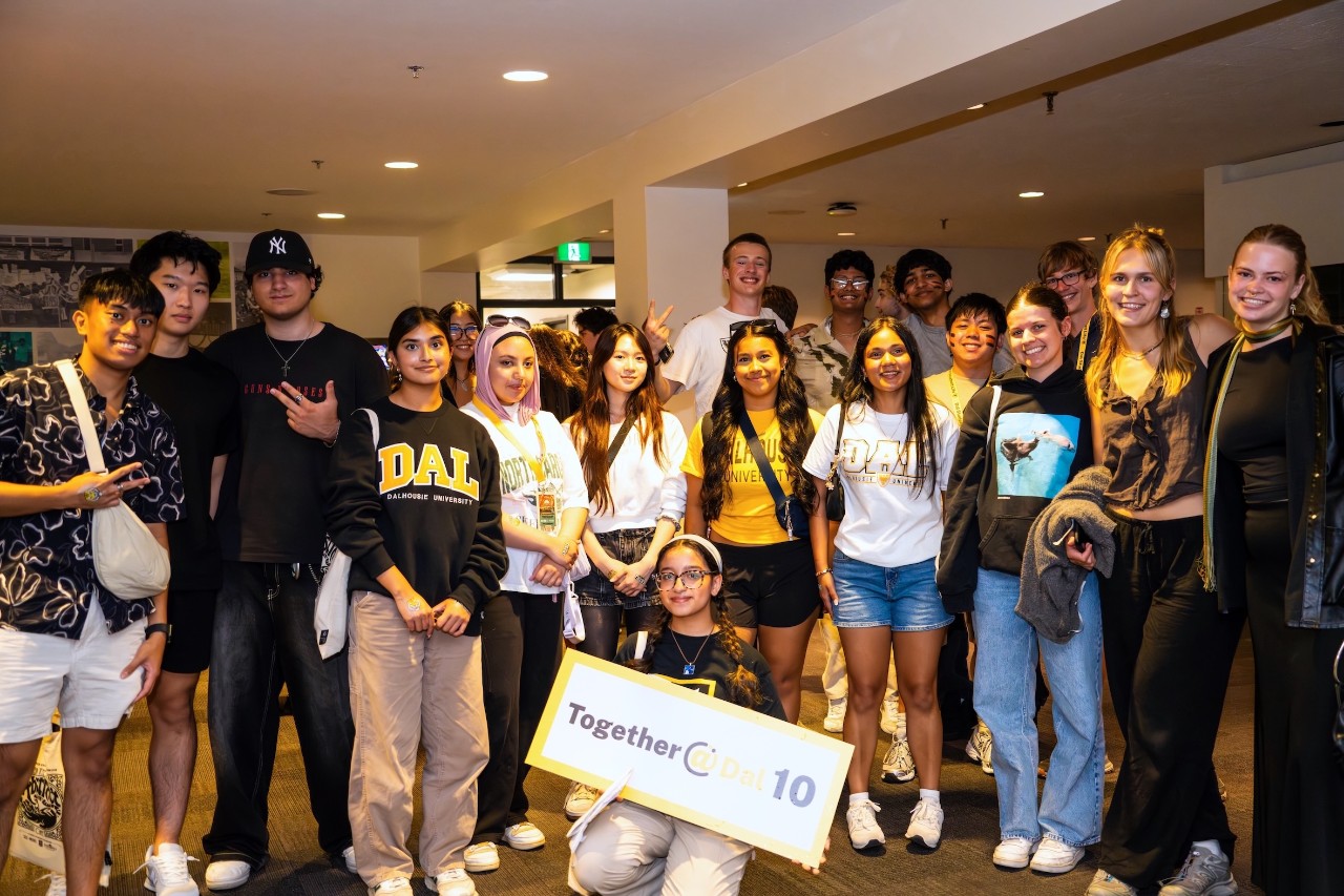 A group of new students standing together in Dal attire during orientation week, and participating in Together at Dal orientation activities.
