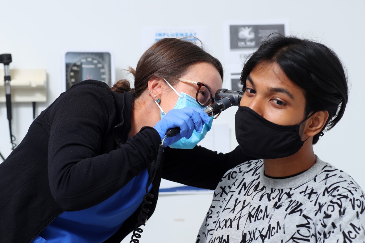 Student getting their ears checked by a nurse at the health clinic