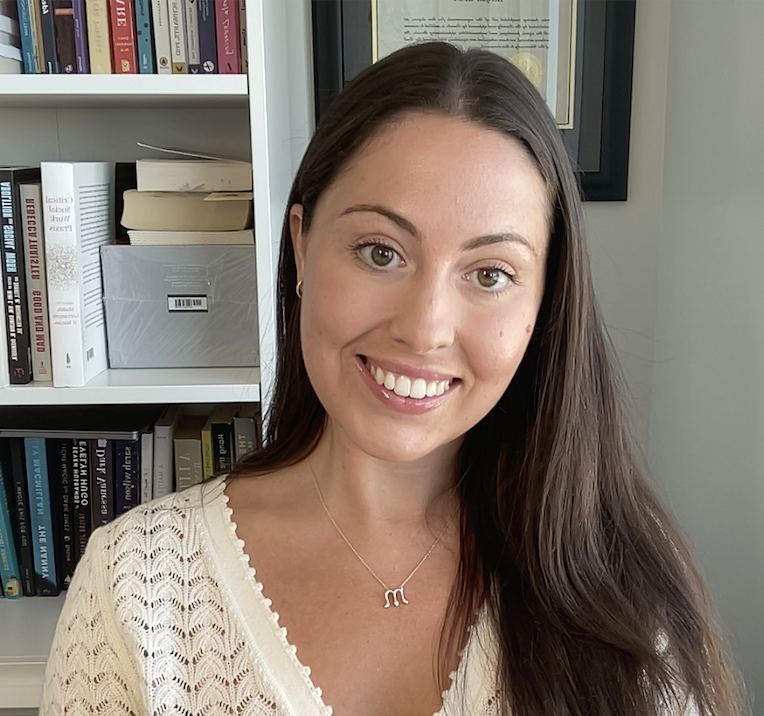 A portrait of Megan Rowe wearing a cream-coloured v-neck sweater.