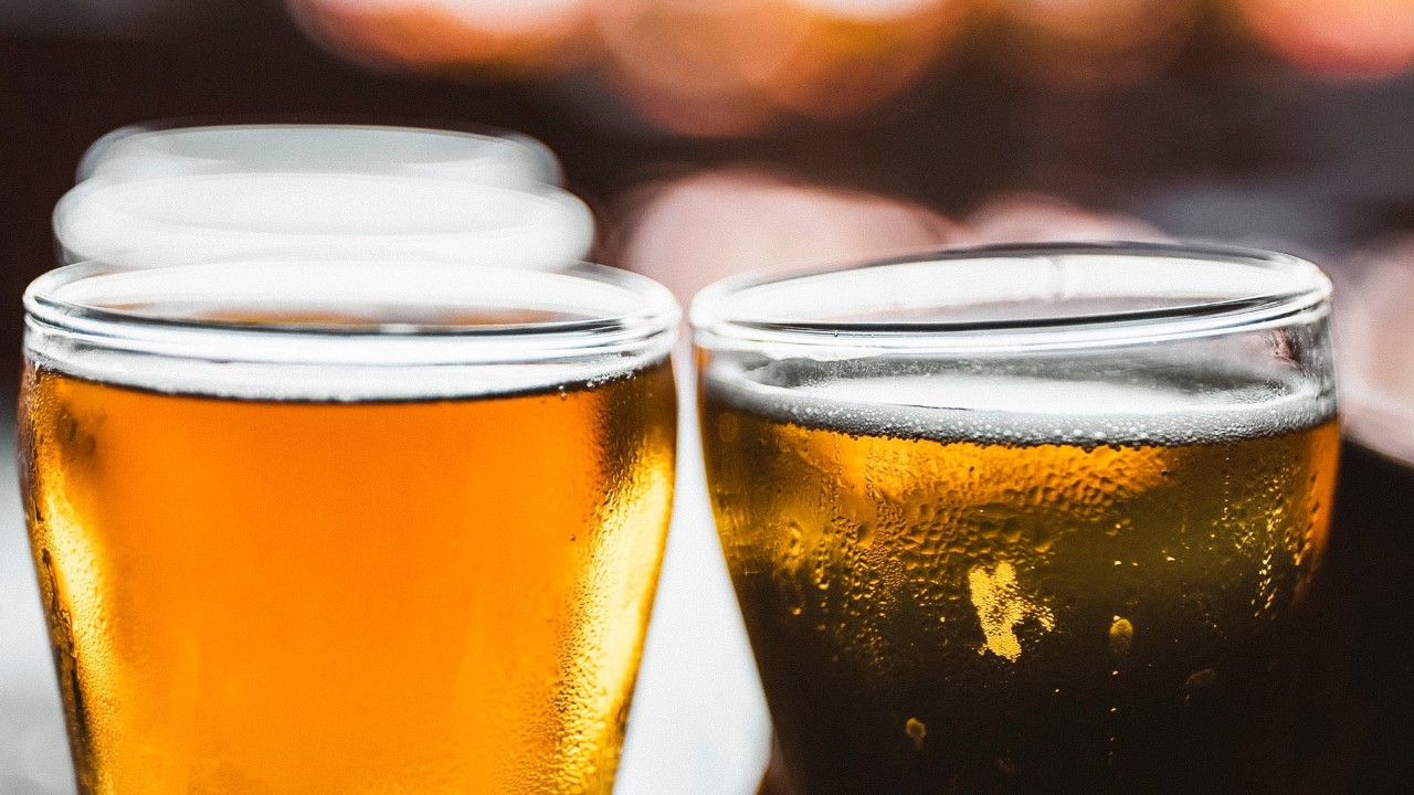 two beers sitting on a wooden table