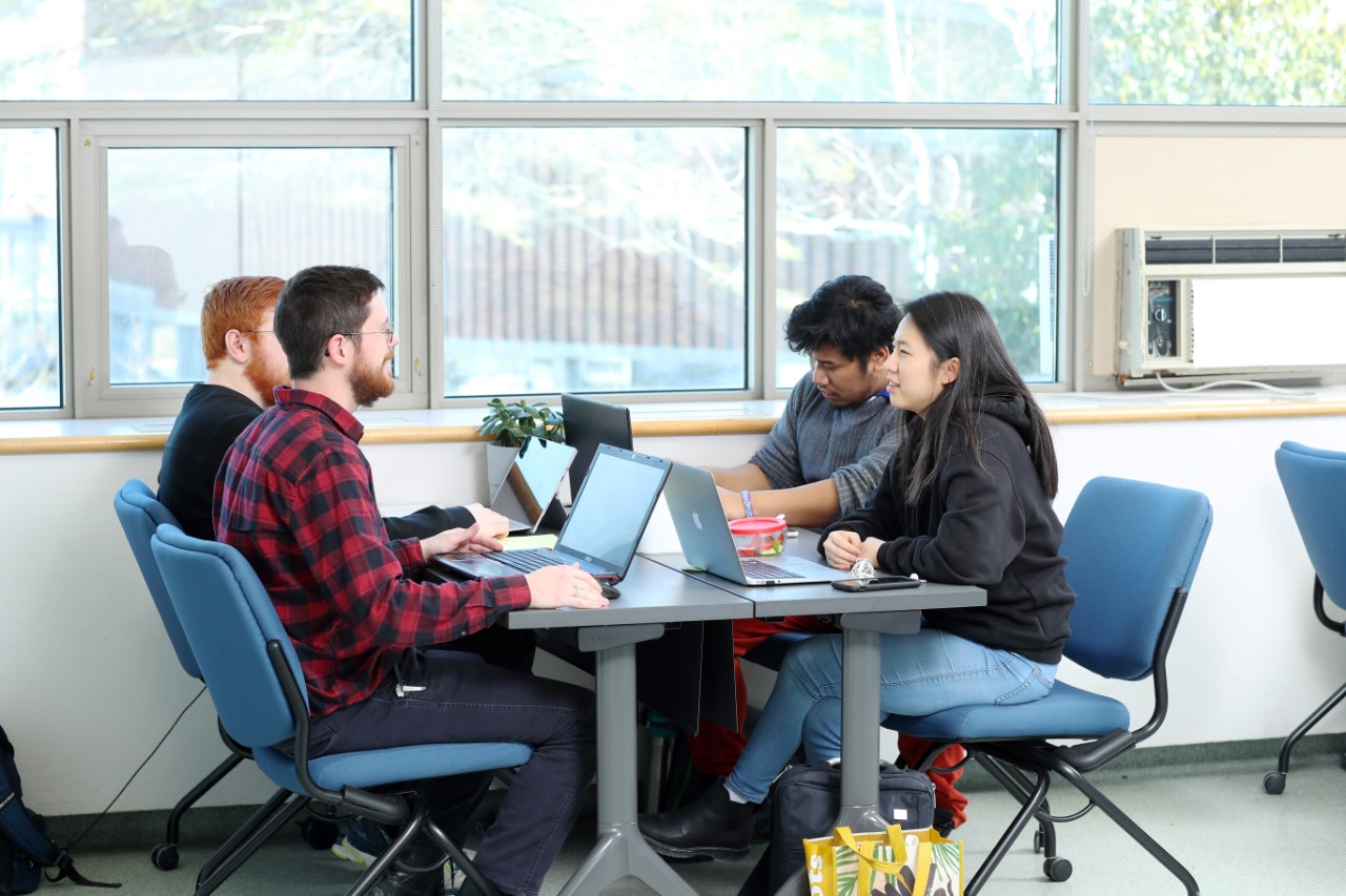 a group of studets sit at a table together