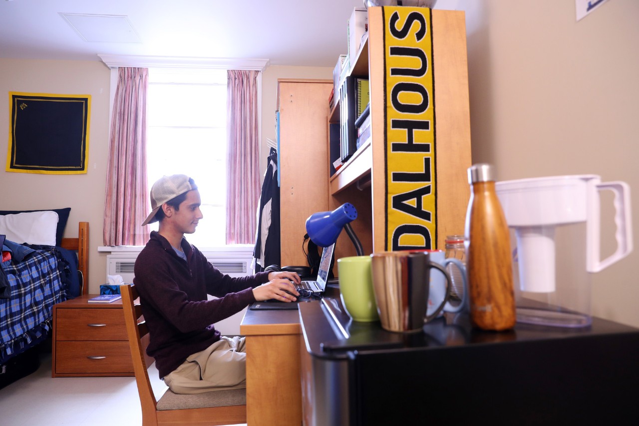 Student on laptop in residence room of Shirreff Hall on Studley campus