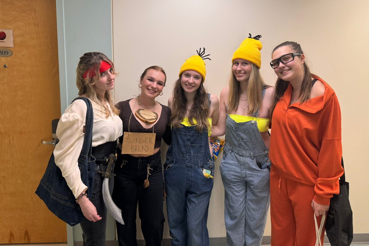A group of residents dressed in Halloween costumes while participating in a residence event. 