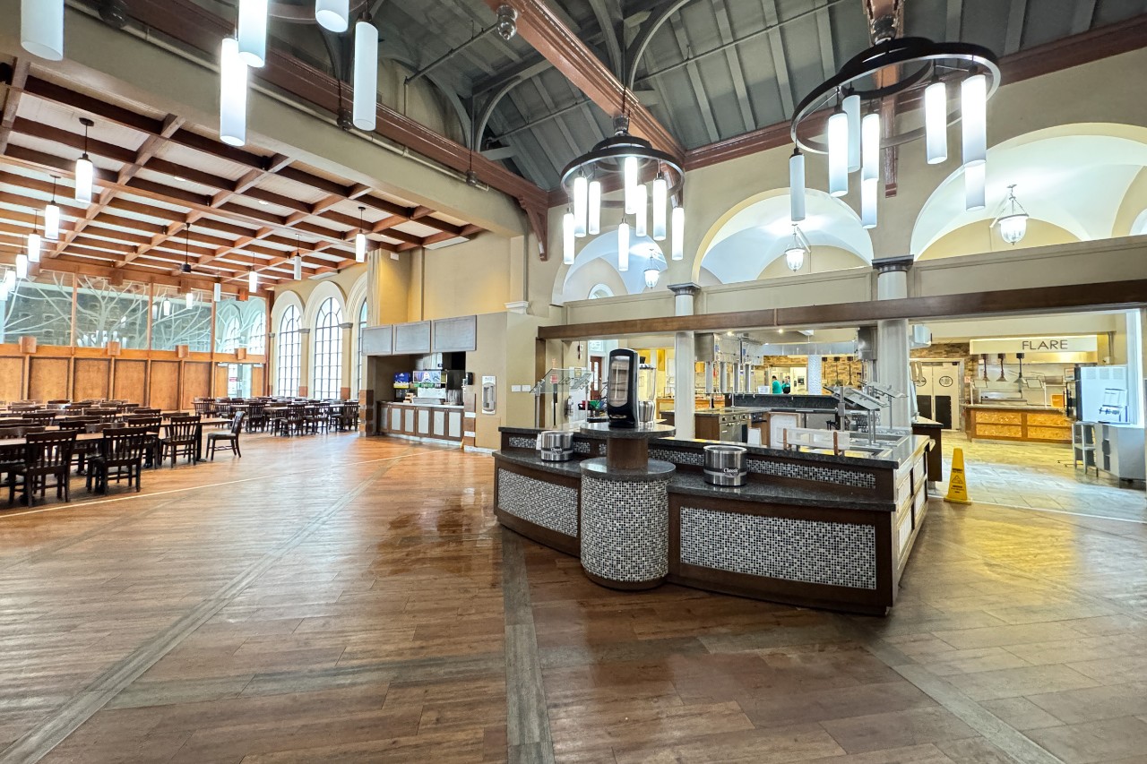 A wide shot of Shirreff Dining Hall, showing large windows with plenty of natural light and long wooden tables. 