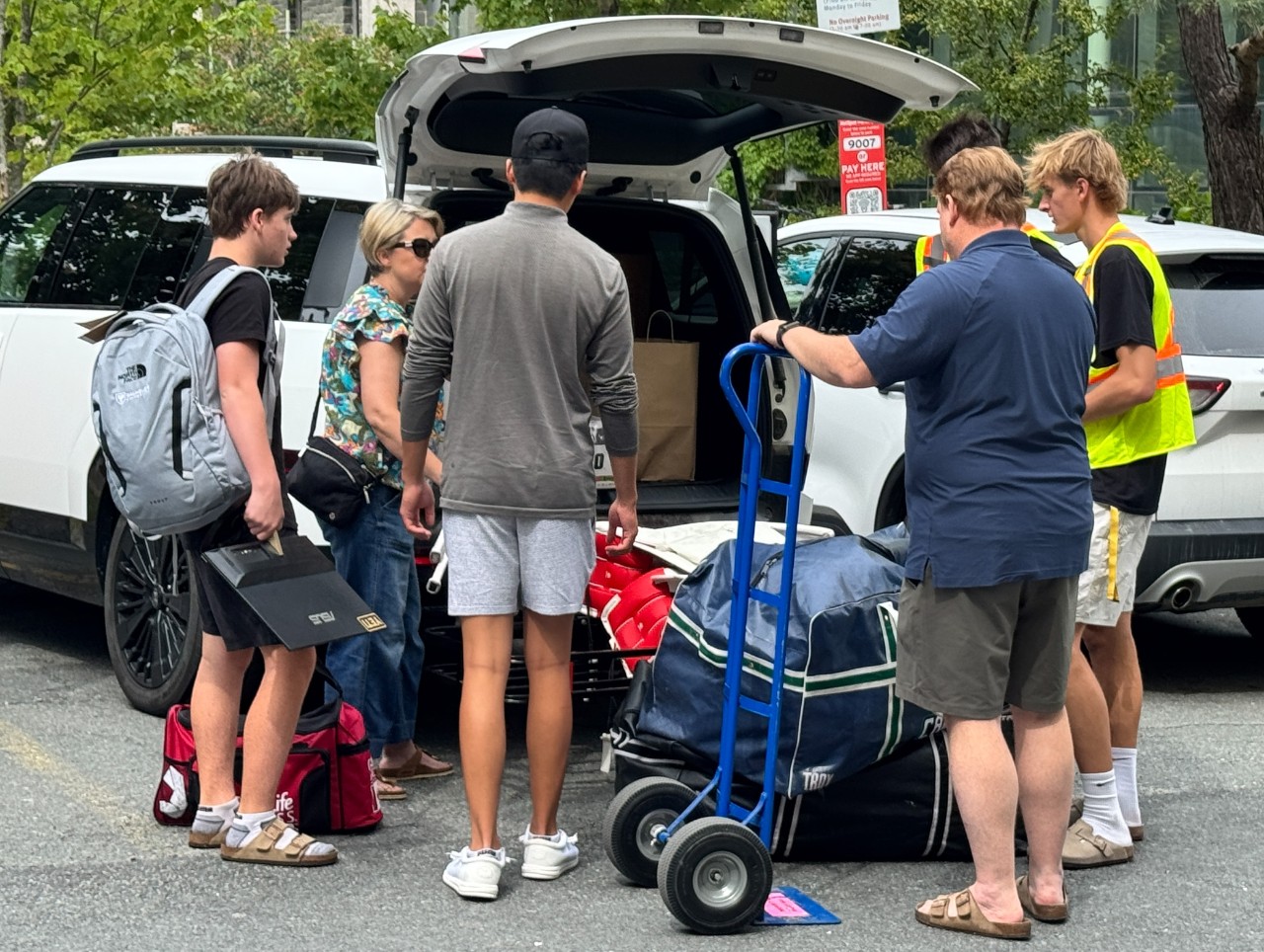 A family unloads their vehicle near Risley Hall with the help of student volunteers on move-in day. 