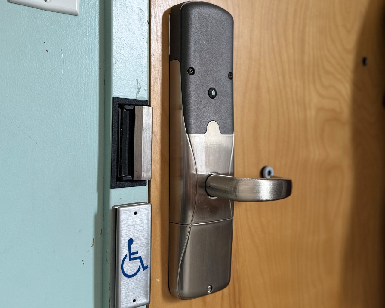 The door button and handle in an accessble room in Risley Hall for the automatic opener