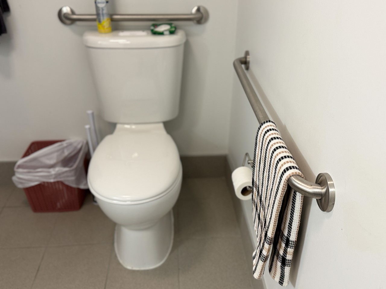 The grab bars around the toilet in an accessible bathroom in LeMarchant Place