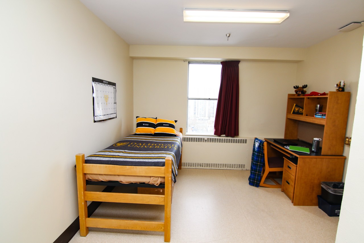 A single room in Gerard Hall, fully furnished with bed, desk, wardrobe and storage