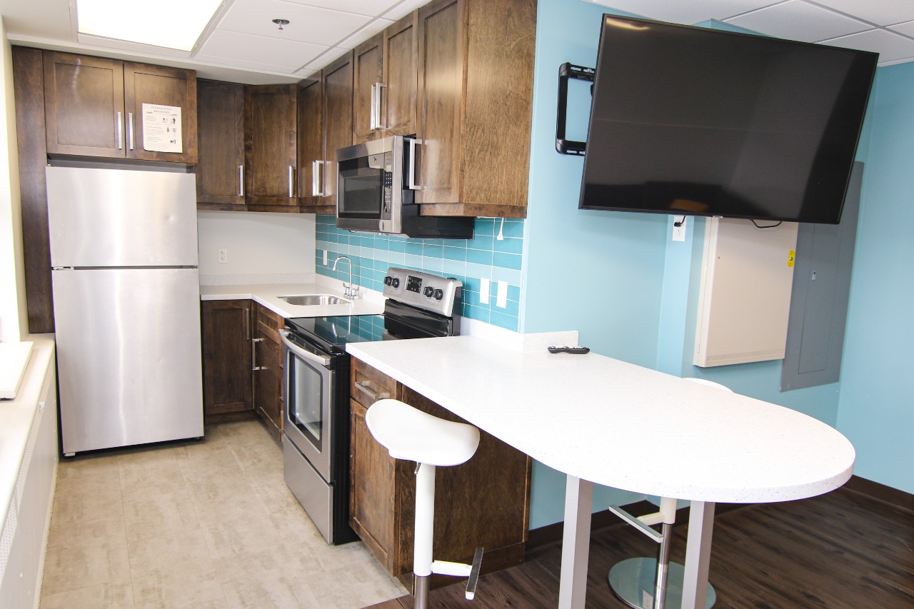A lounge in Gerard Hall with a large tv and a newly renovated kitchen