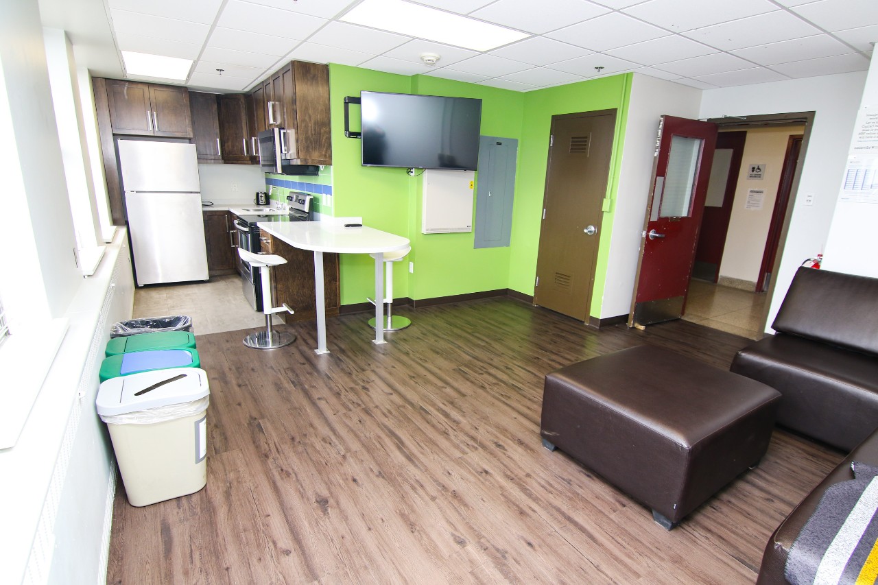 One of the floor lounges in Gerard Hall, with lime green paint, comfortable seating and a full kitchen.