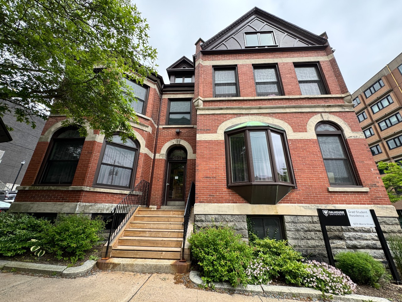 The brick exterior of Grad House on the Sexton Campus, with classic features such as arched windows and decorated gables. 
