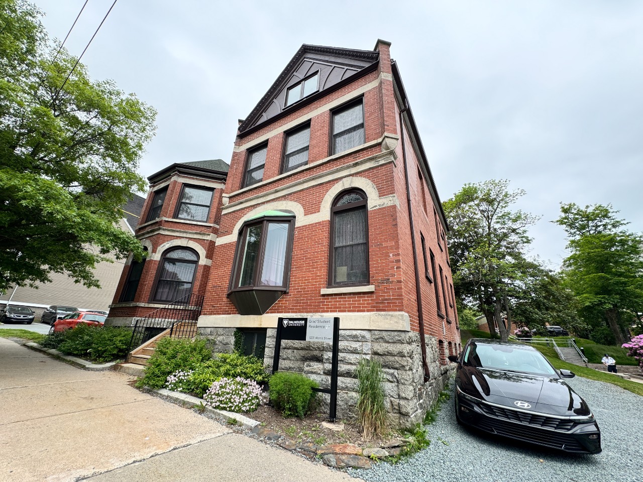 A wide-angle image of the red brick exterior of Grad House