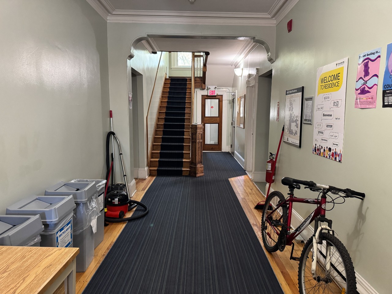 The lobby at Grad House, with trash receptacles and a grand staircase