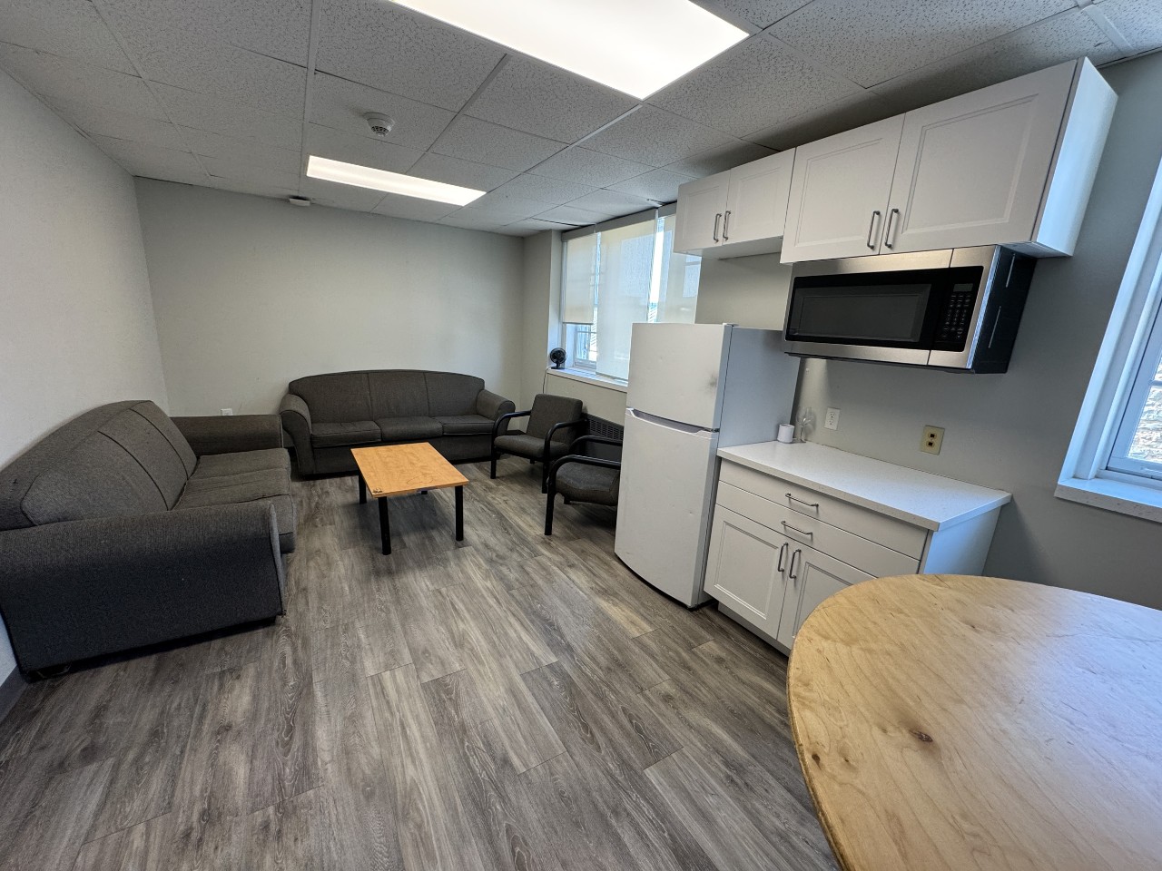 A lounge in Henderson House with grey sofas and a kitchenette