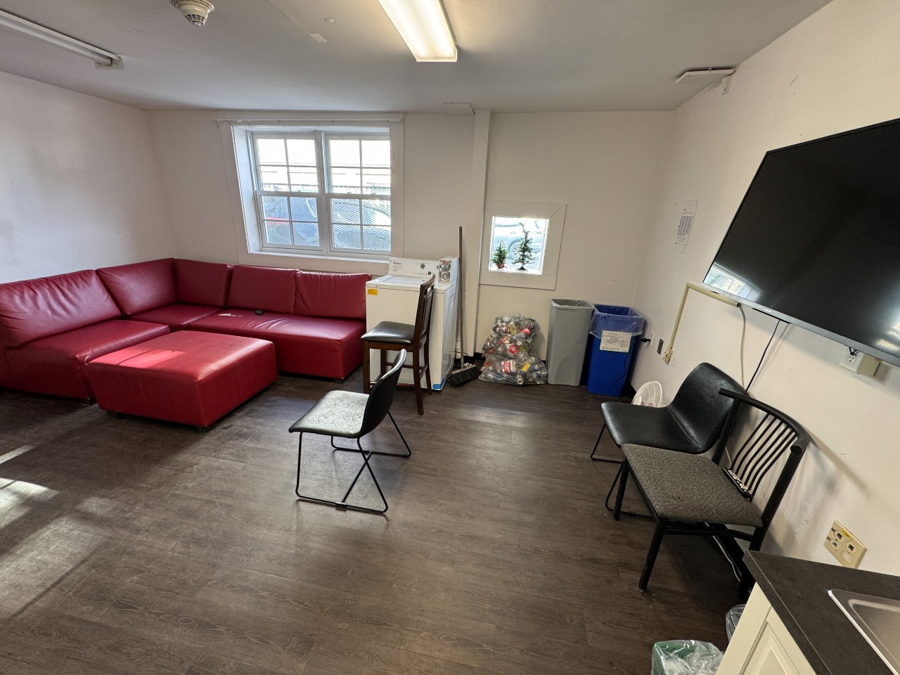 The lounge in Studley House with a red leather sofa and kitchenette