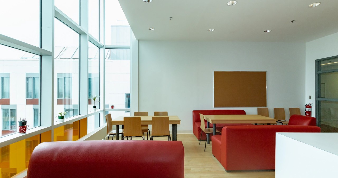 A kitchen lounge in LeMarchant Place, featuring red seating, a white kitchen island, and full kitchen