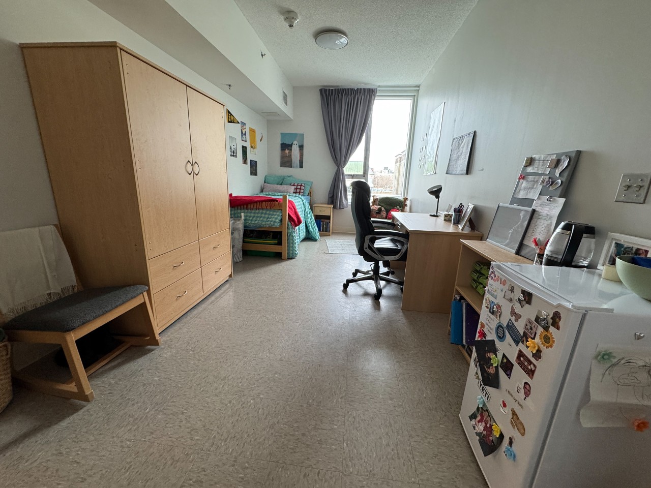 A wide-angle photo of an accessible room in LeMarchant Place, showing furniture and mini fridge