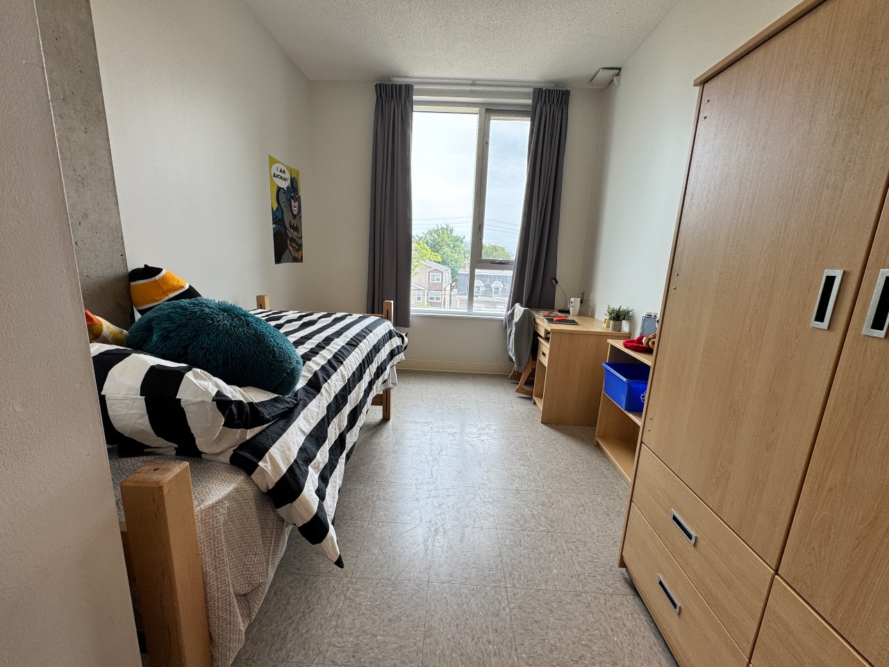 A single room with shared bath, featuring bed, wardrobe, desk, and bookshelf