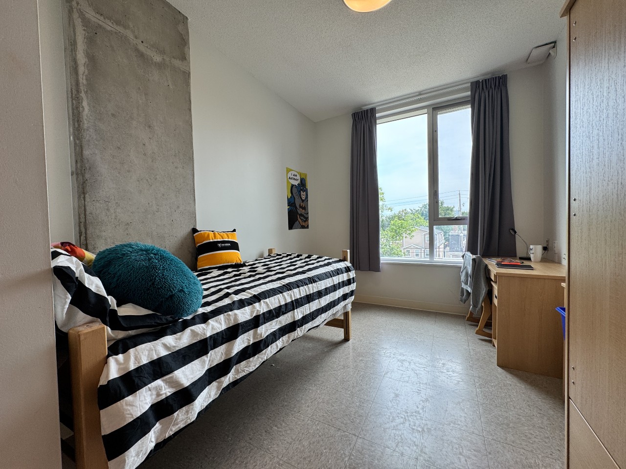 A single room with shared bath, featuring bed, wardrobe, desk, and bookshelf