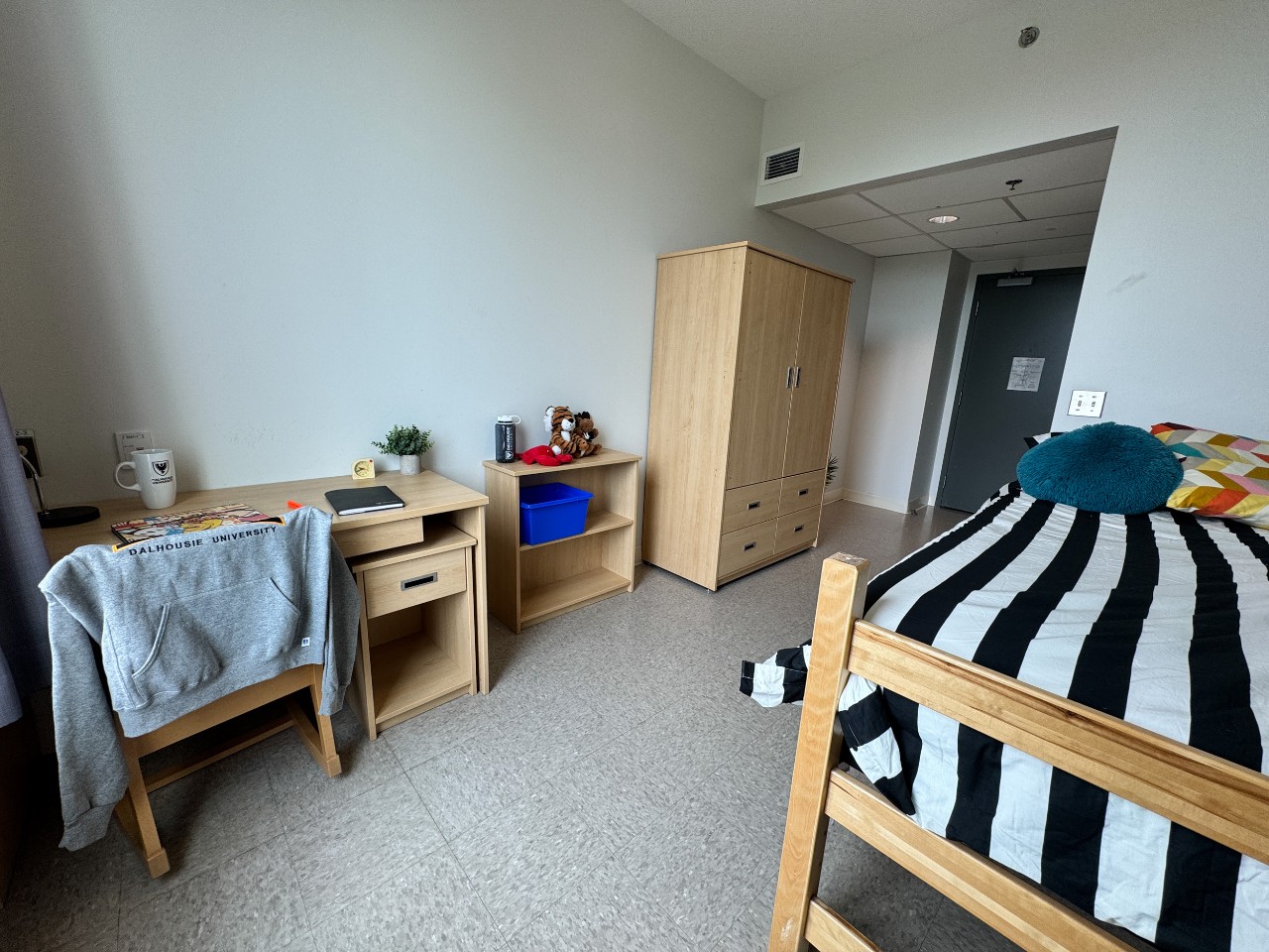 A single room with shared bath, featuring bed, wardrobe, desk, and bookshelf