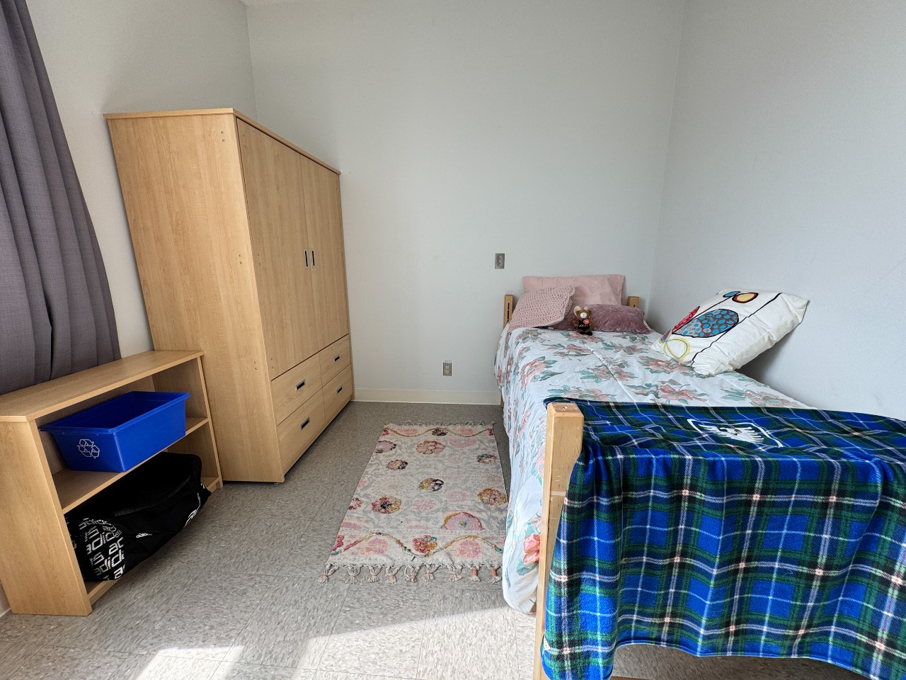 A bedroom in a 4-bedroom suite in LeMarchant Place featuring a bed, wardrobe, bookshelf, and desk