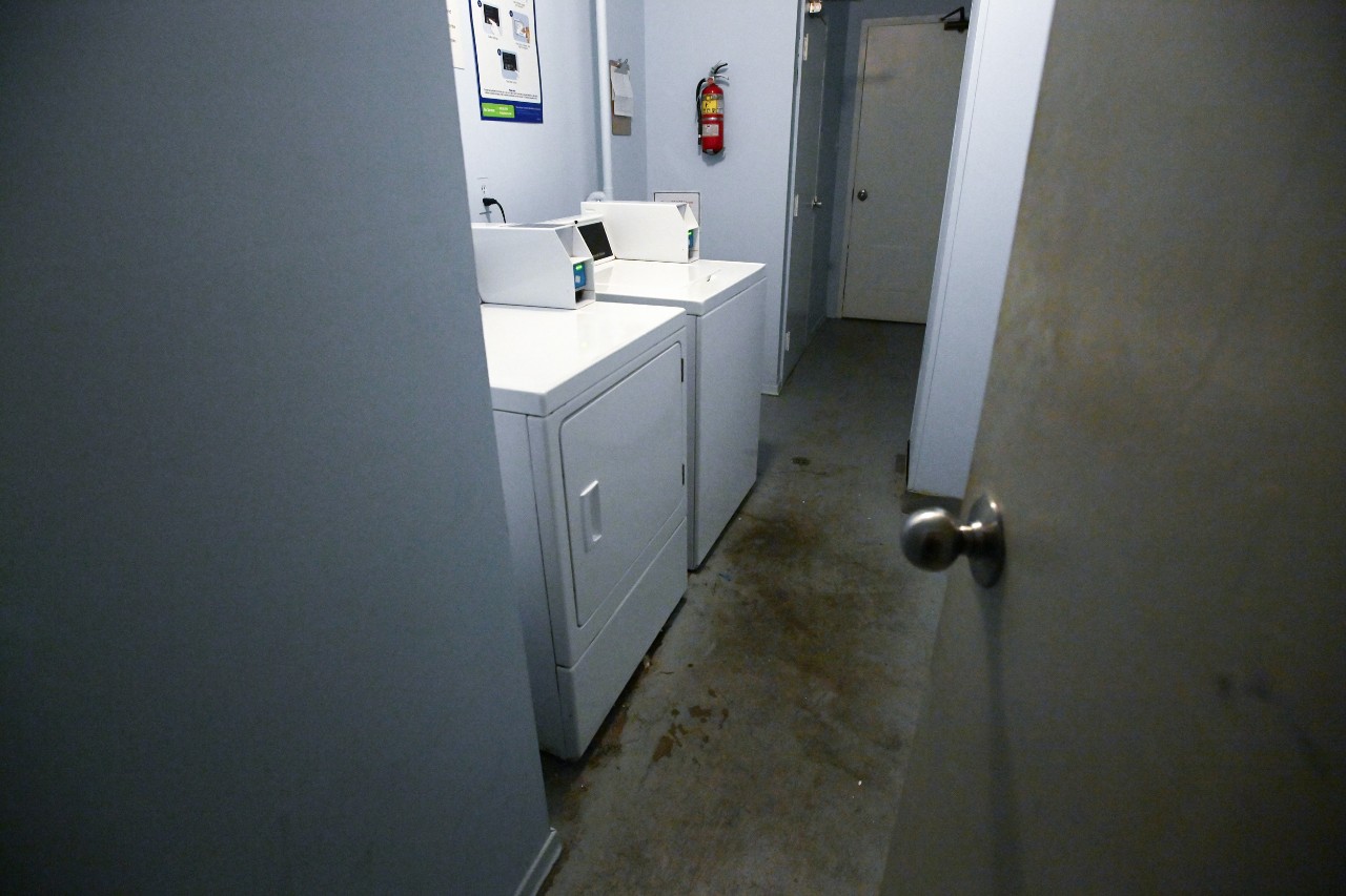 A shared laundry room has coin operated washer and dryer