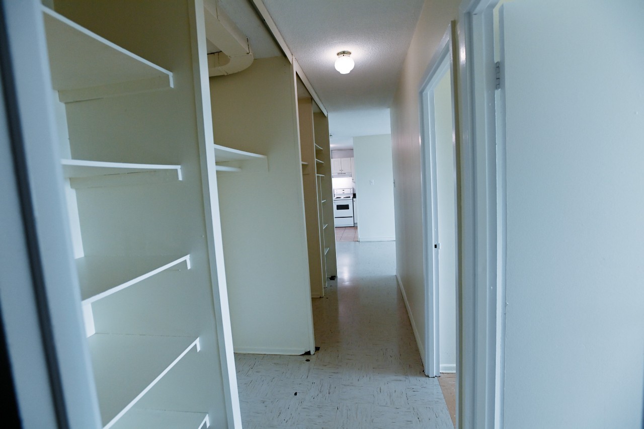 The view down the bedroom hallway, showing plenty of built-in storage shelves and closet space