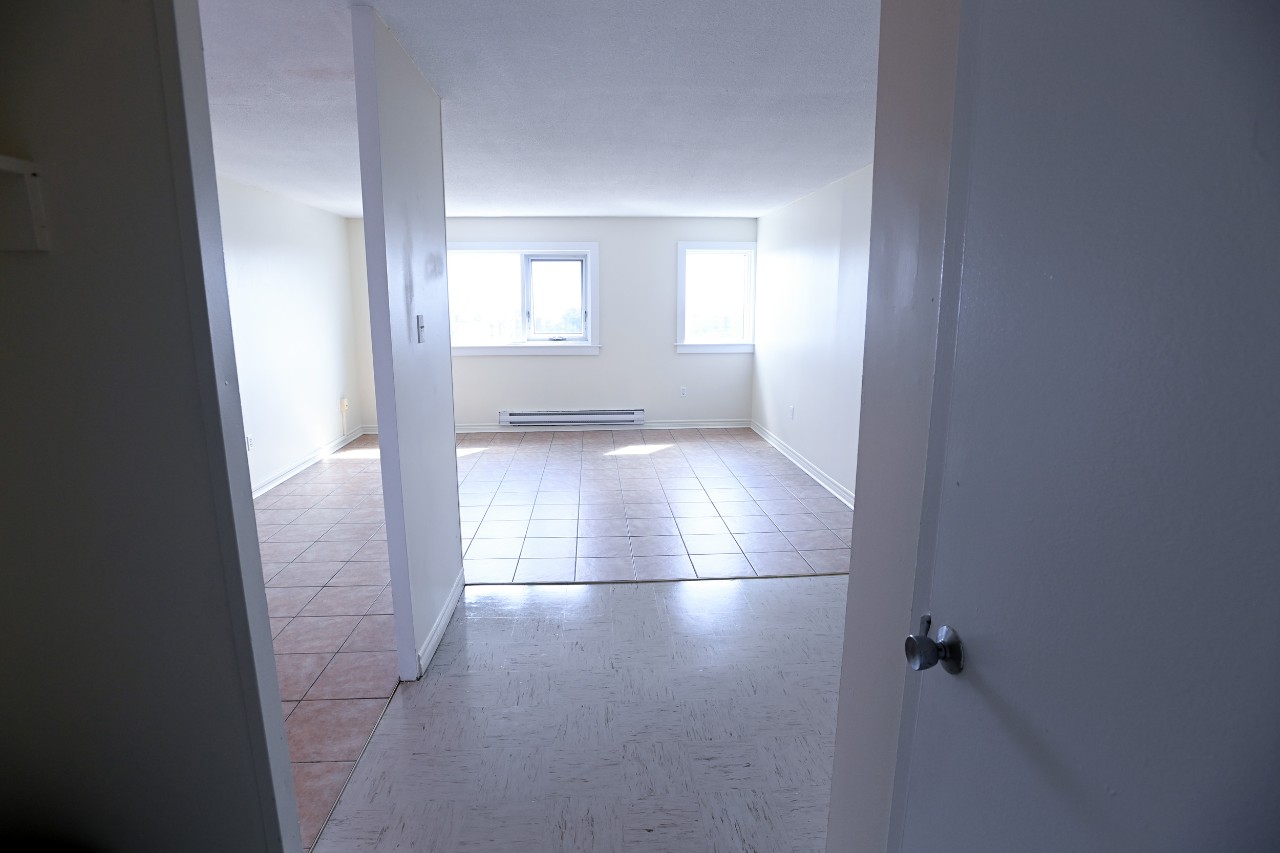 The view from the front entrance into the living area, with the entrance to the kitchen on the left as well as the hall closet