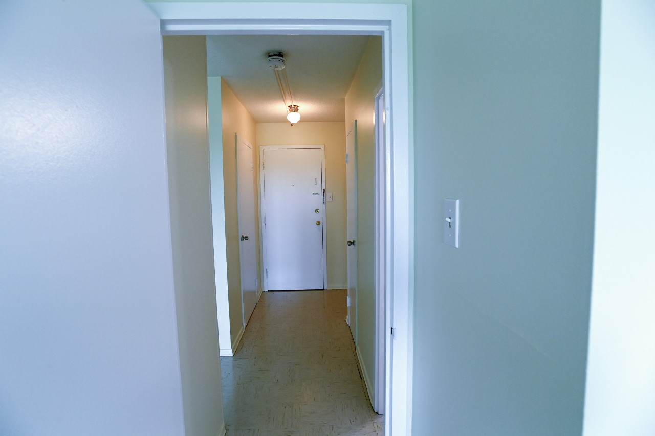 The hallway leading from the front entrance to a one-bedroom unit