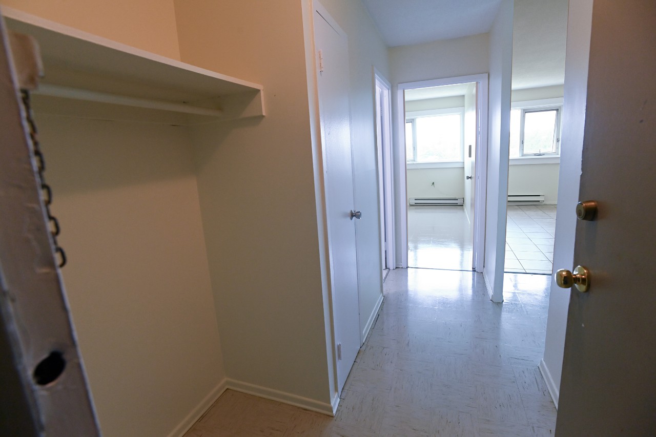 The view from the front door of a one-bedroom unit - showing the hall closet, and entrance to bedroom and to living area