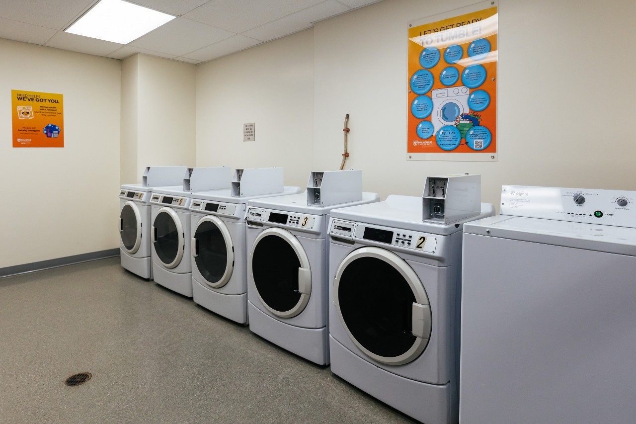 Several coin-operated washing machines in a laundry room in Risley Hall